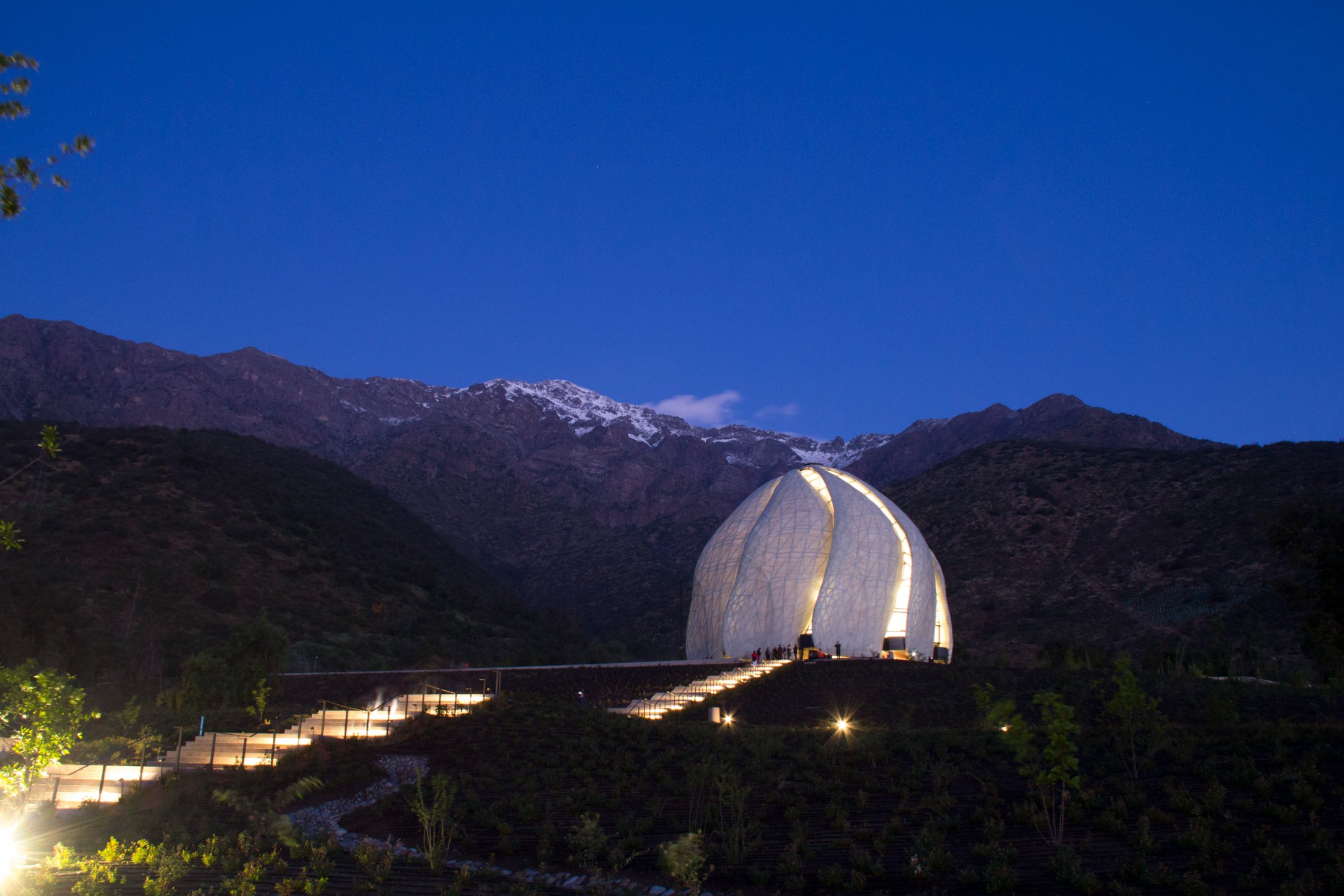 El Templo Bahá’í iluminado de noche bajo los Andes nevados